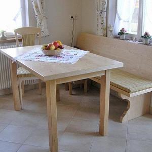 Rechteckiger Holztisch mit heller Polsterbank