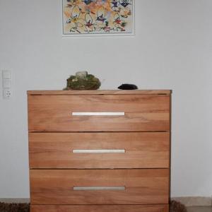 Heller Schubladenschrank aus Holz mit silbernen Griffen