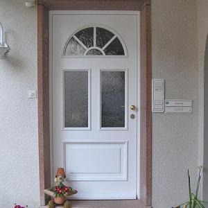 Weiße Haustür mit verglastem Rundbogenfenster