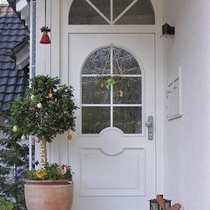 Weiße Haustür mit verglastem Rundbogenfenster